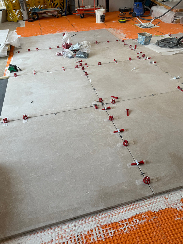 Hand-finished 1200x1200mm limestone tiles are being (very carefully) laid